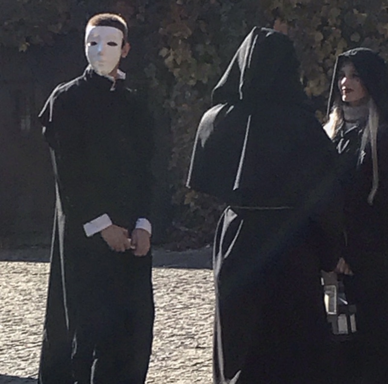 Members of the Secret Brotherhood in black robes and white masks